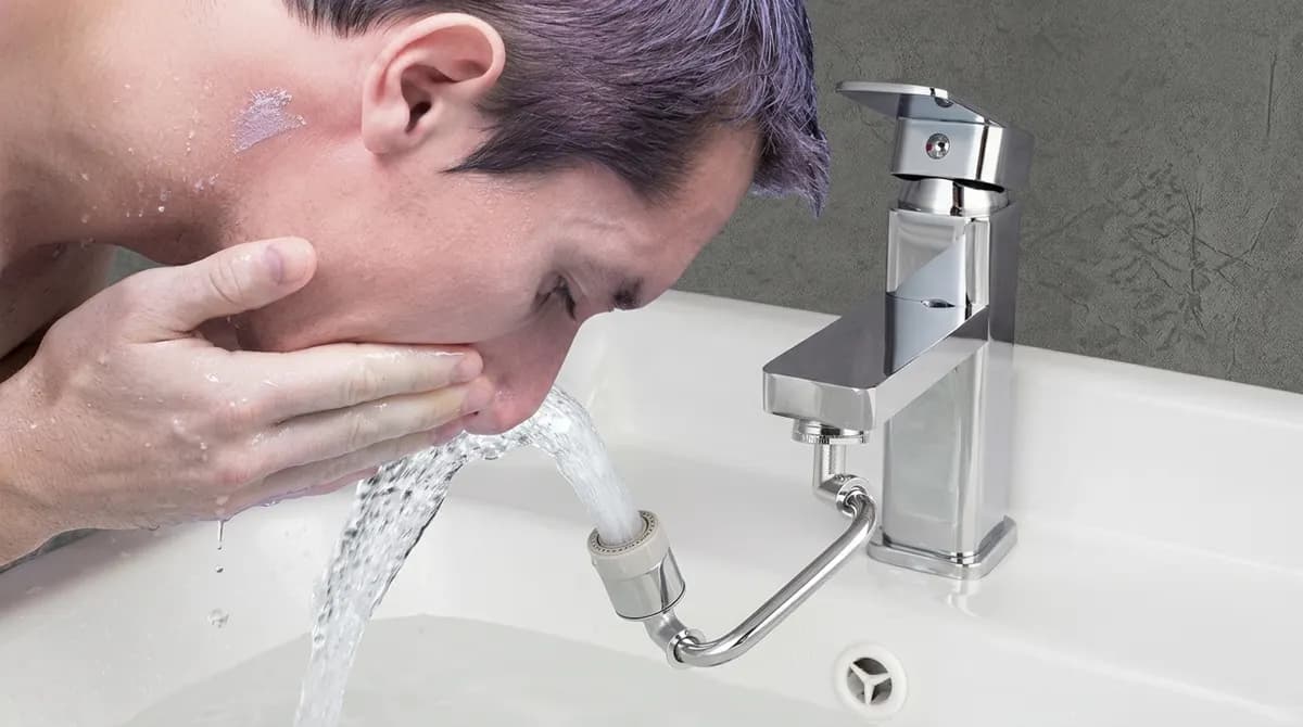 Person washing their face using the Hibbent 1080° faucet extender at a kitchen sink
