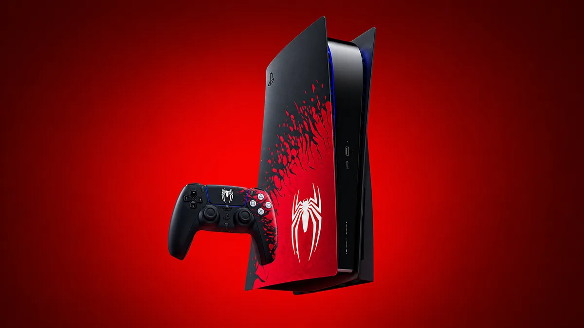 PlayStation 5 console with a black and red Spider-Man themed cover beside a matching DualSense controller on a red background